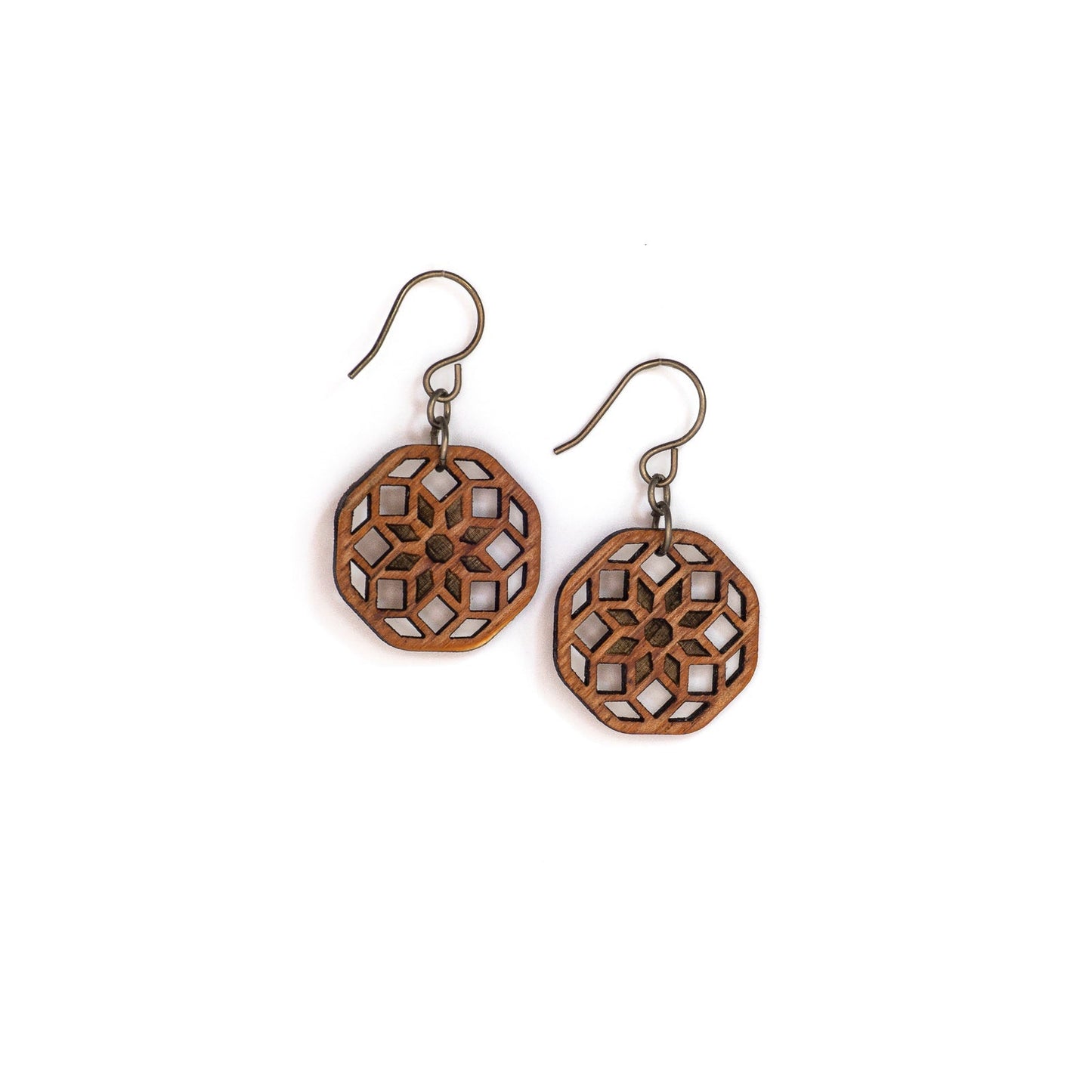 Two small hexagonal mahogany wood earrings with a laser cut design. The design is illustrative of sacred geometry the cross-sectional lines forming an eight pointed flower at the center with two rows of diamonds emanating from it.