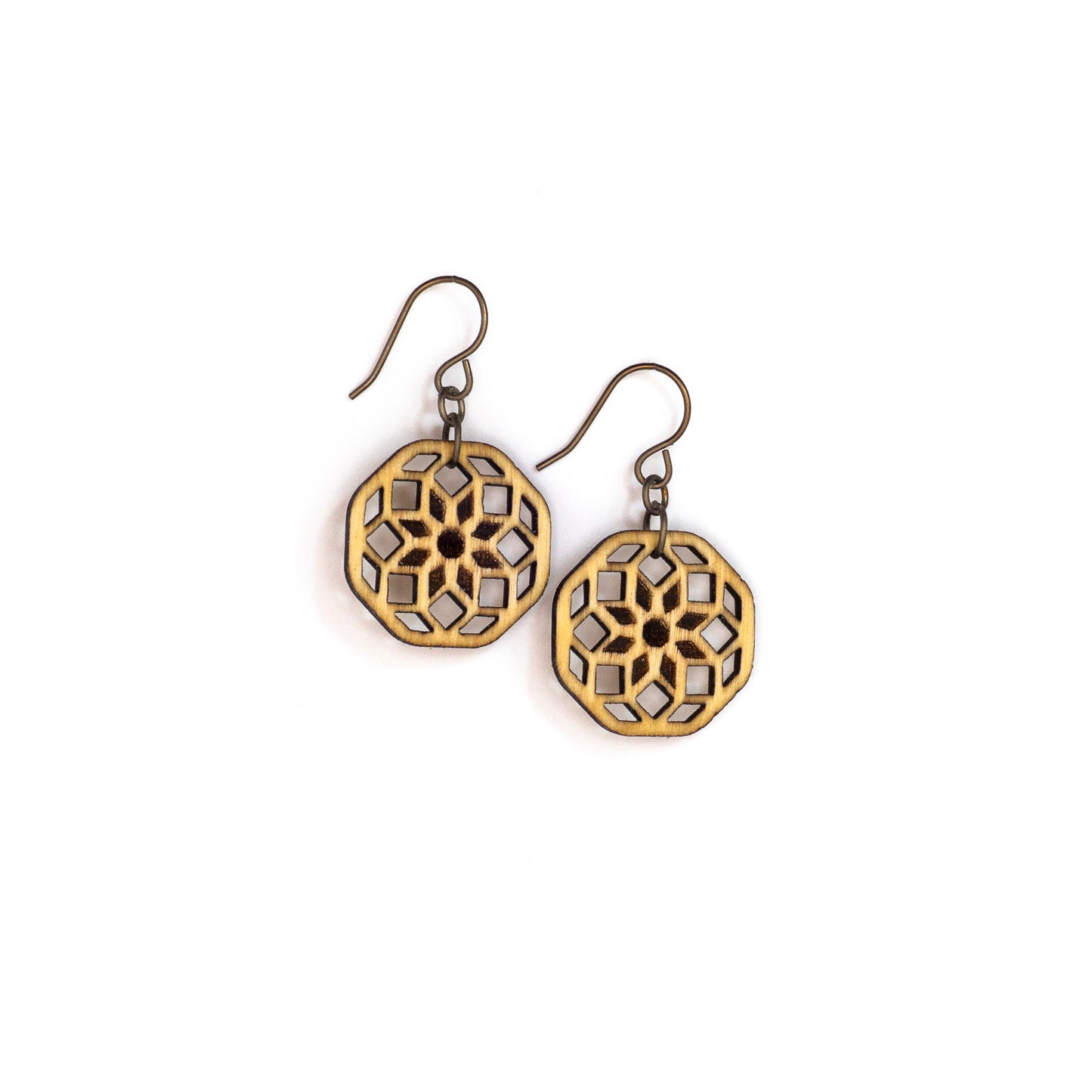 Two small hexagonal birch wood earrings with a laser cut design. The design is illustrative of sacred geometry the cross-sectional lines forming an eight pointed flower at the center with two rows of diamonds emanating from it.