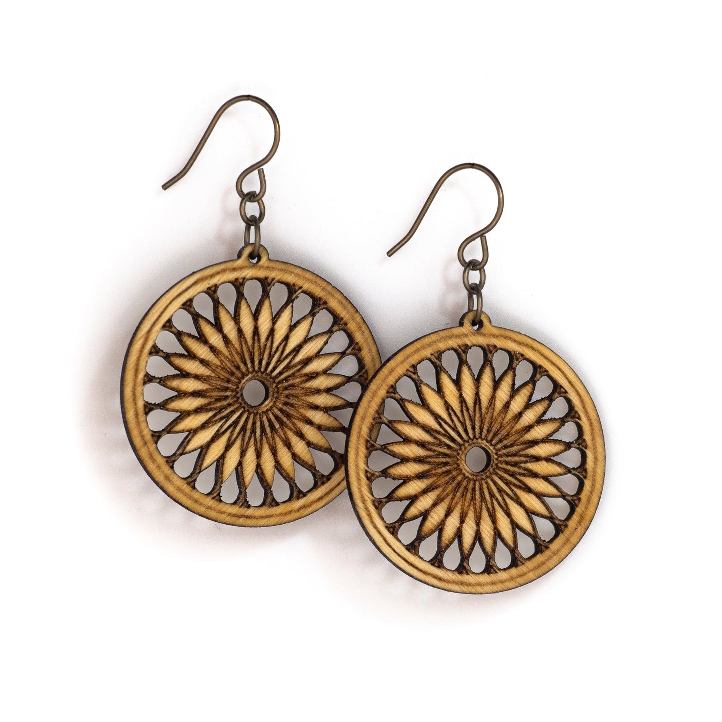 Two round birch earrings. The earring face boasts a sacred geometric design, a repeating shape which fractals and loosely resembles a cross section of a citrus fruit or a 24 petalled daisy.