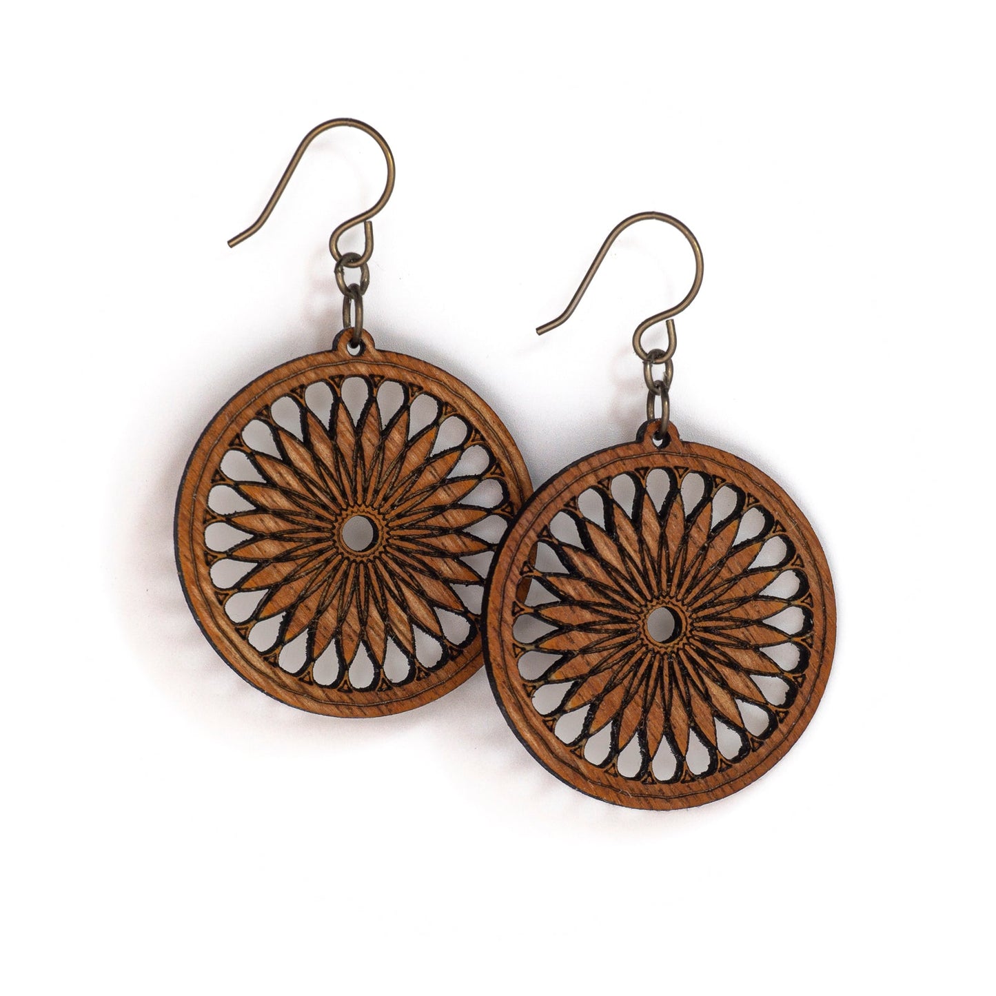 Two round mahogany earrings. The earring face boasts a sacred geometric design, a repeating shape which fractals and loosely resembles a cross section of a citrus fruit or a 24 petalled daisy.