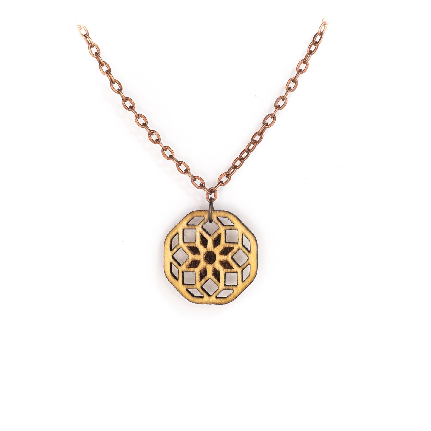 A delicate copper chain hangs in a 'V', at its apex is a small hexagonal birch wood pendant with a laser cut design. The design is illustrative of sacred geometry the cross-sectional lines forming an eight pointed flower at the center with two rows of diamonds emanating from it.