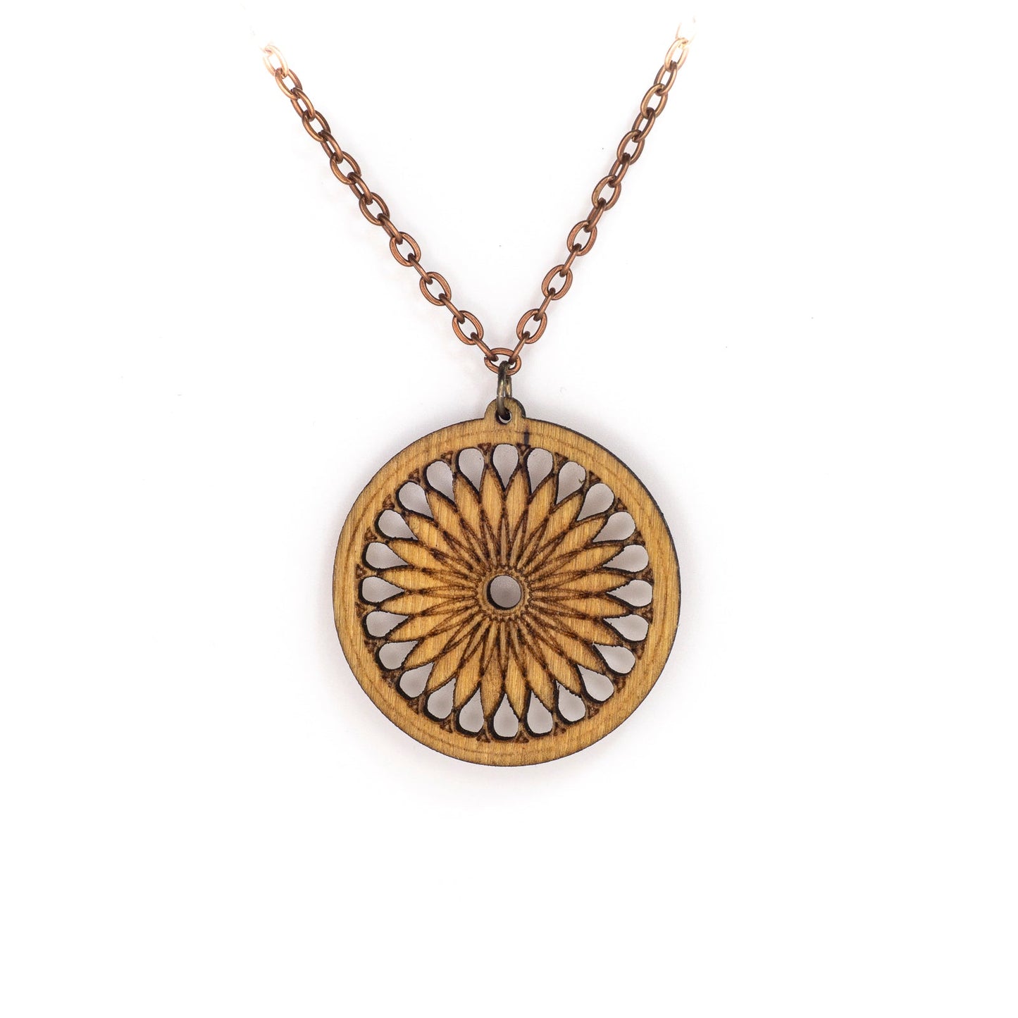 A delicate copper chain hangs in a 'V', at its apex is a round birch pendant. The pendant's face boasts a sacred geometric design, a repeating shape which fractals and loosely resembles a cross section of a citrus fruit or a 24 petalled daisy.