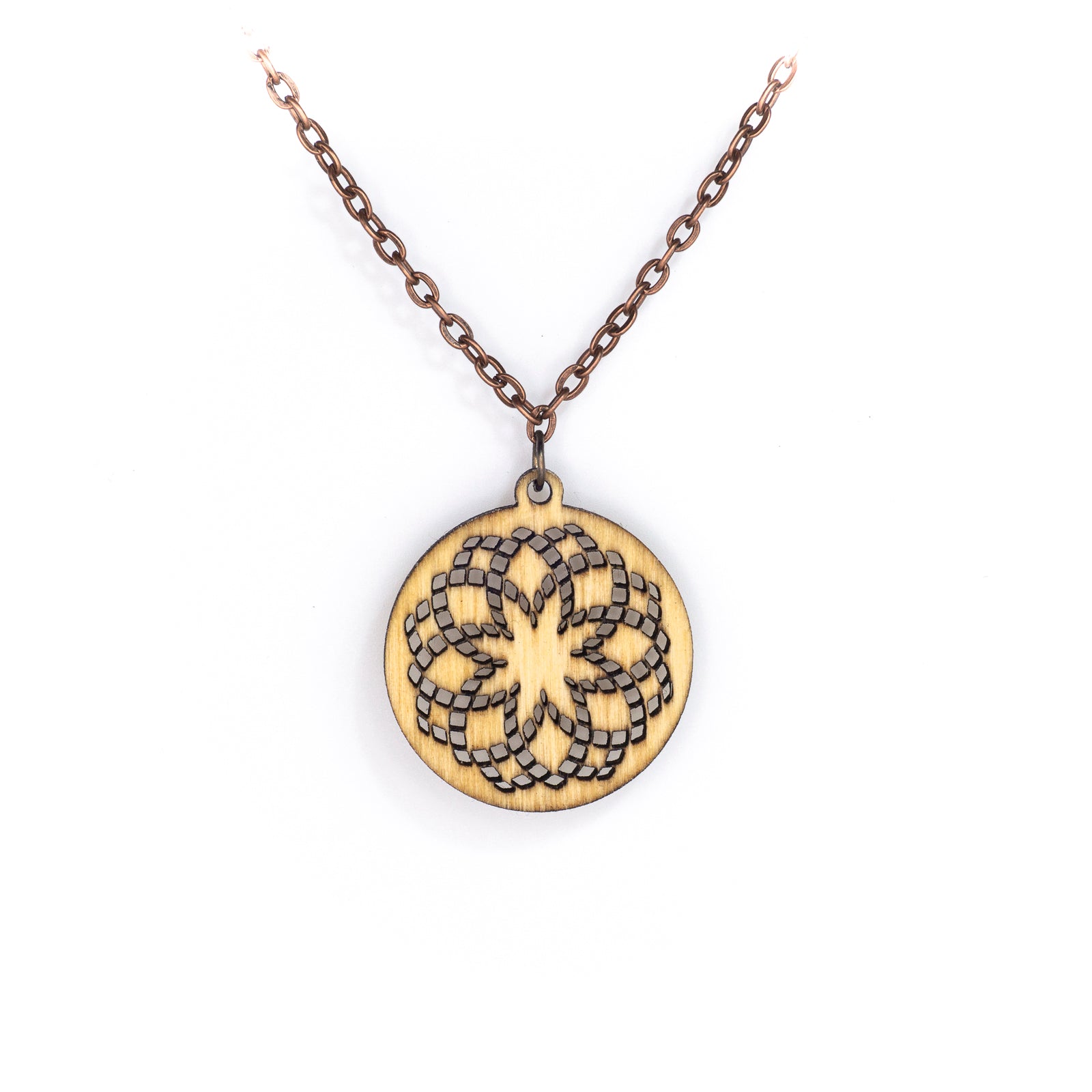 A delicate copper chain hangs in a 'V', at its apex is a small round birch wood pendant with a laser cut design. The design is illustrative of sacred geometry with repeating circles creating a fractal effect loosely resembling a flower with an eight pointed star in the center.